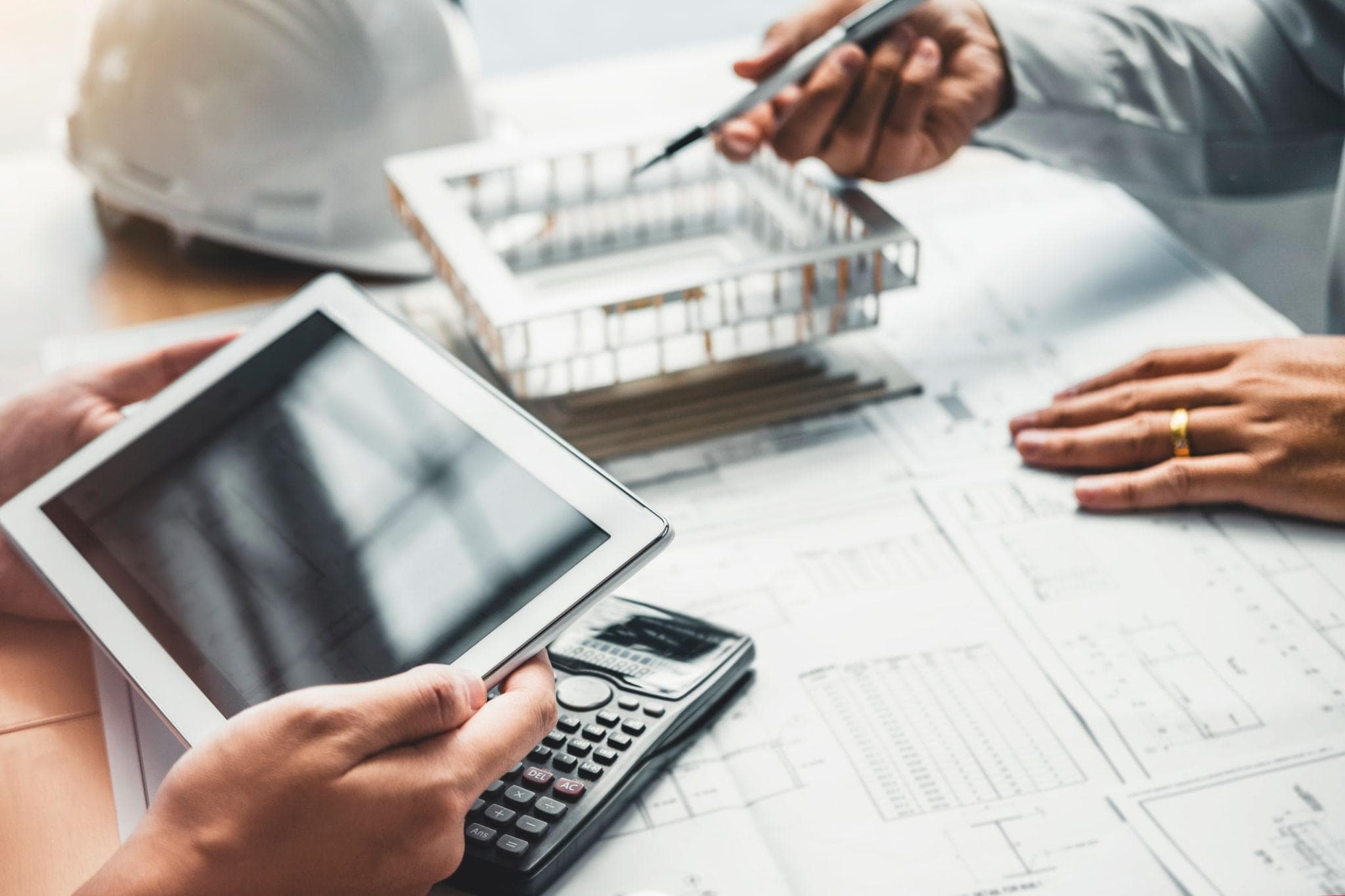 Engineers reviewing project plans and equipment models on blueprints